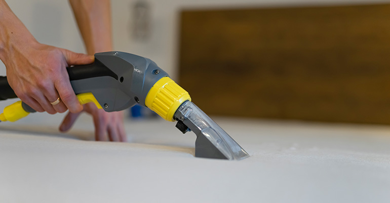 Professional upholstery cleaning extraction tool removing dirt from fabric